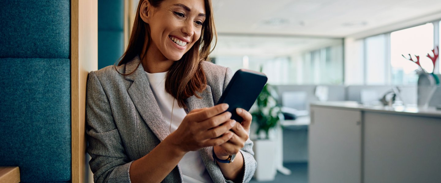Berufserfahrene Frau schaut auf ihr Handy